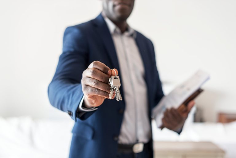 real estate agent holding clipboard and house key